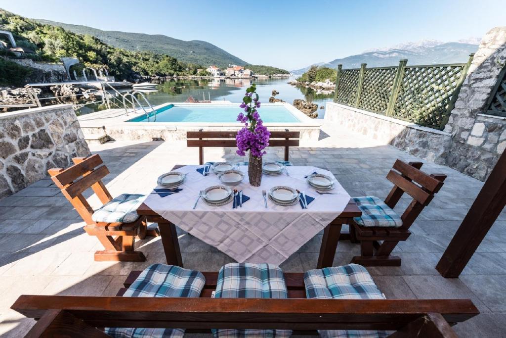 a table and chairs on a patio with a pool at Apartments Kovinic in Tivat