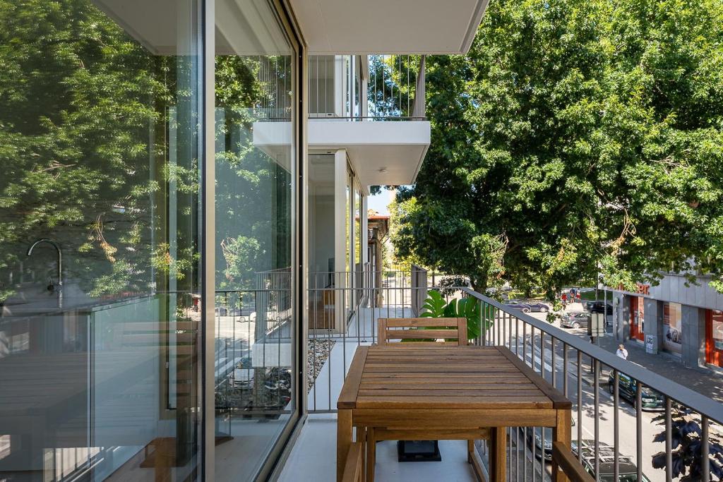 una mesa de madera en el balcón de un edificio en GuestReady - Lux staycation in Boavista en Oporto