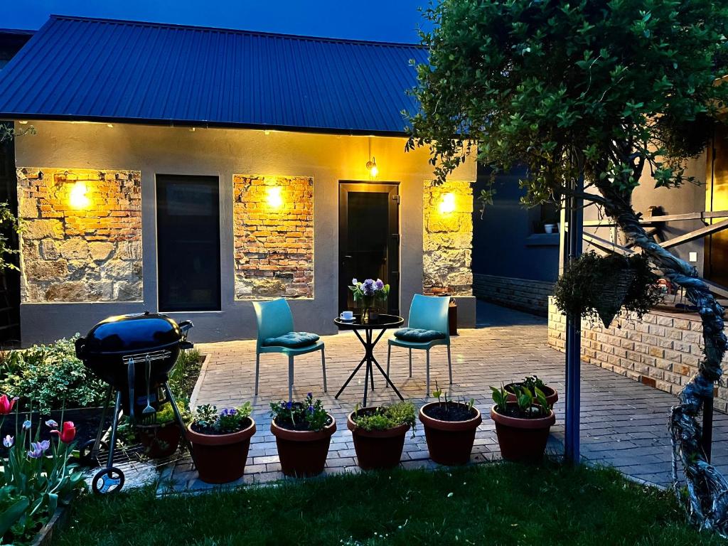 a patio with two chairs and a table and some plants at Tiny Barn House in Chişinău
