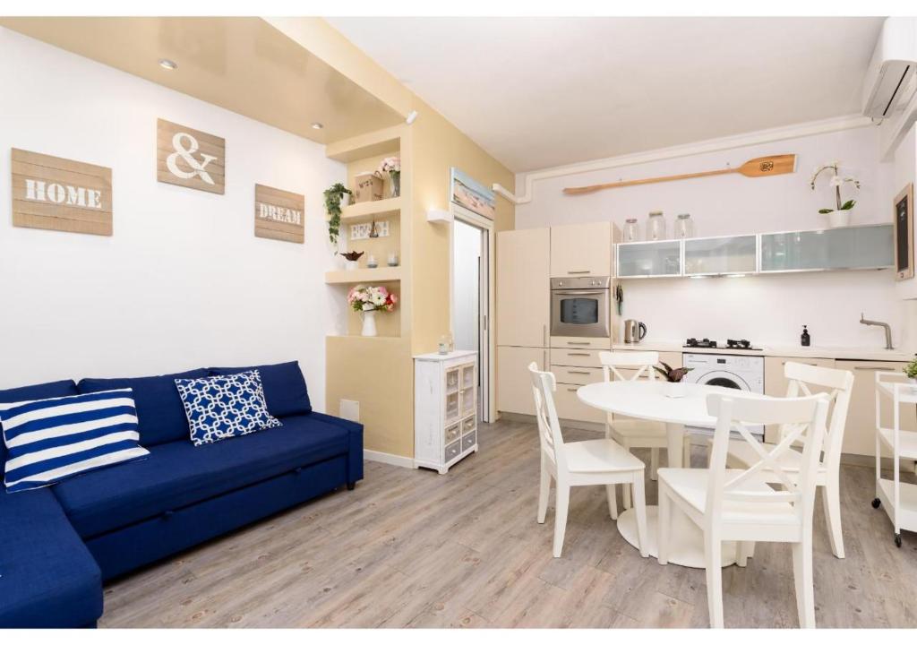 a living room with a blue couch and a table at Diamante Sea Apartment - Eleganza sul Mare in Varigotti