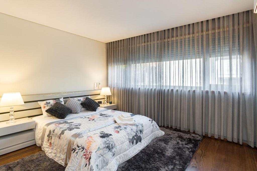 1 dormitorio con cama y ventana grande en GuestReady - Freixo lux with Douro River view, en Oporto