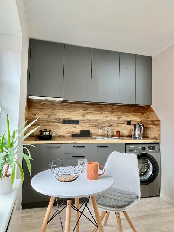 a kitchen with a white table and a white chair at City centre one room apartment in Tartu