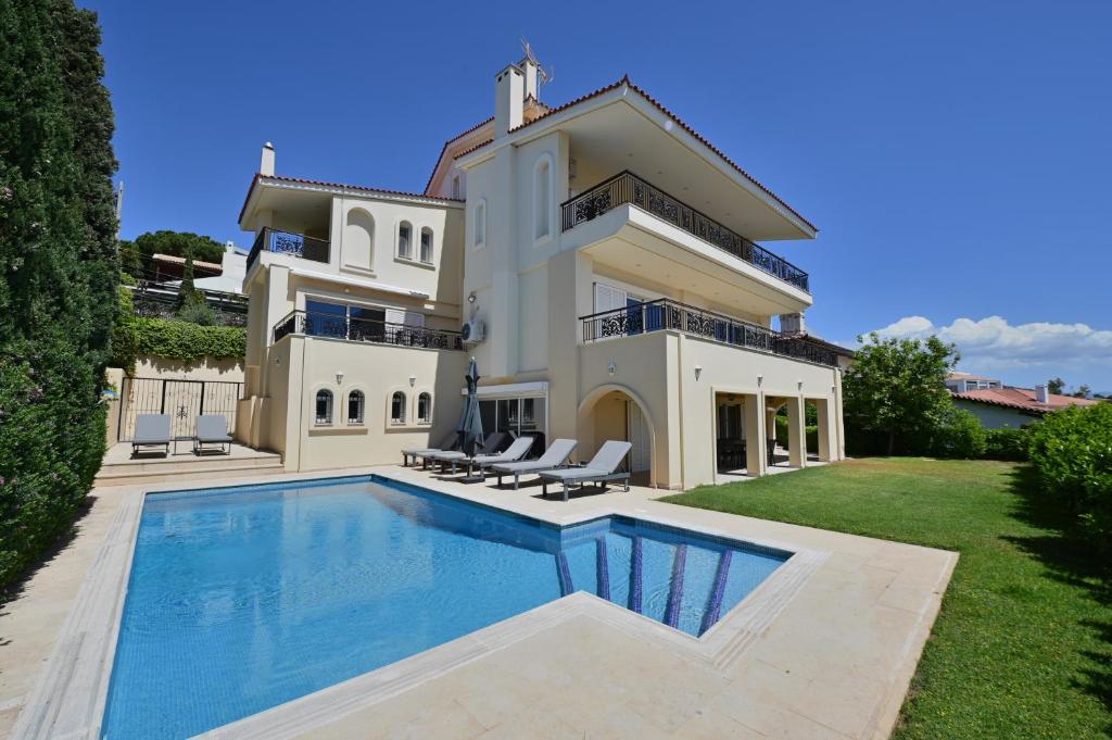 a large house with a swimming pool in front of it at Villa Domus Riviera in Athens
