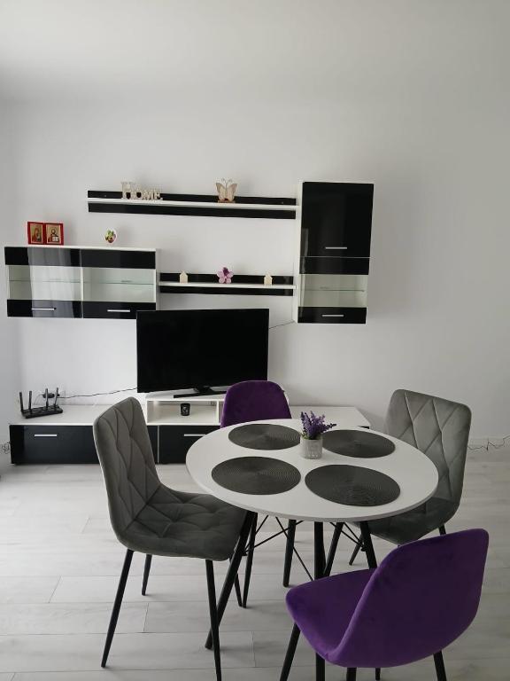 a dining room with a table and purple chairs at Forest View in Câmpulung Moldovenesc