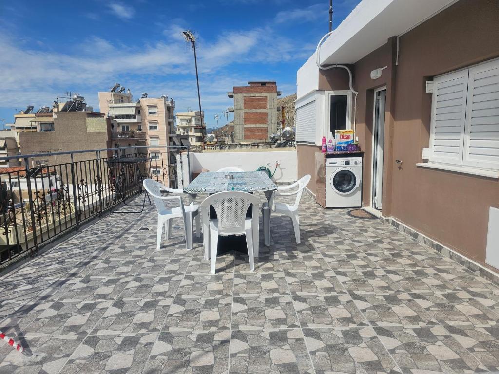 patio ze stołem i krzesłami na balkonie w obiekcie Monda Apartment w Pireusie
