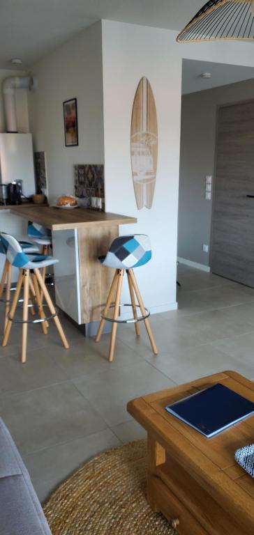 un salon avec une cuisine avec des tabourets dedans dans l'établissement Bonamour Calluna, à Capbreton