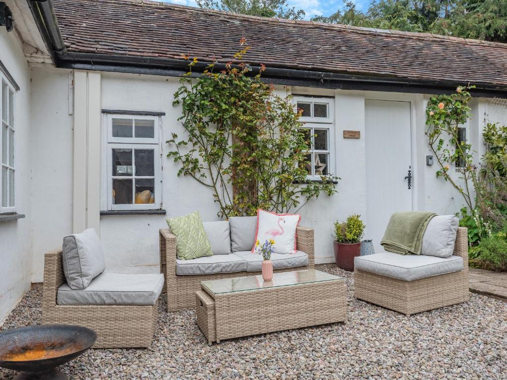 a patio with two couches and a coffee table at Westmoor Annexe in Hereford