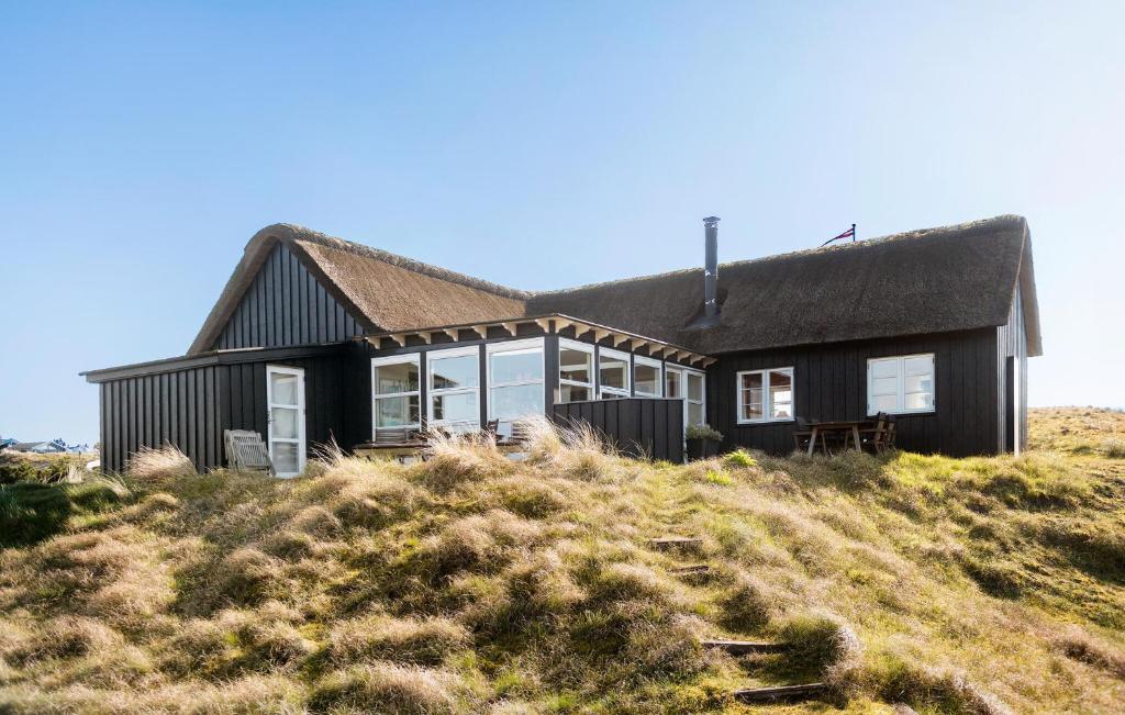 Czarny dom na szczycie wzgórza w obiekcie Awesome Home In Fan With House A Panoramic View w mieście Fanø