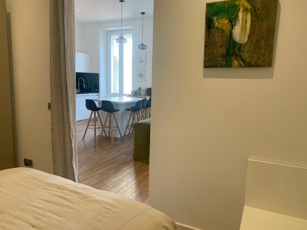 a room with a bed and a kitchen with a table at Appartement Design sur Vauban in Marseille
