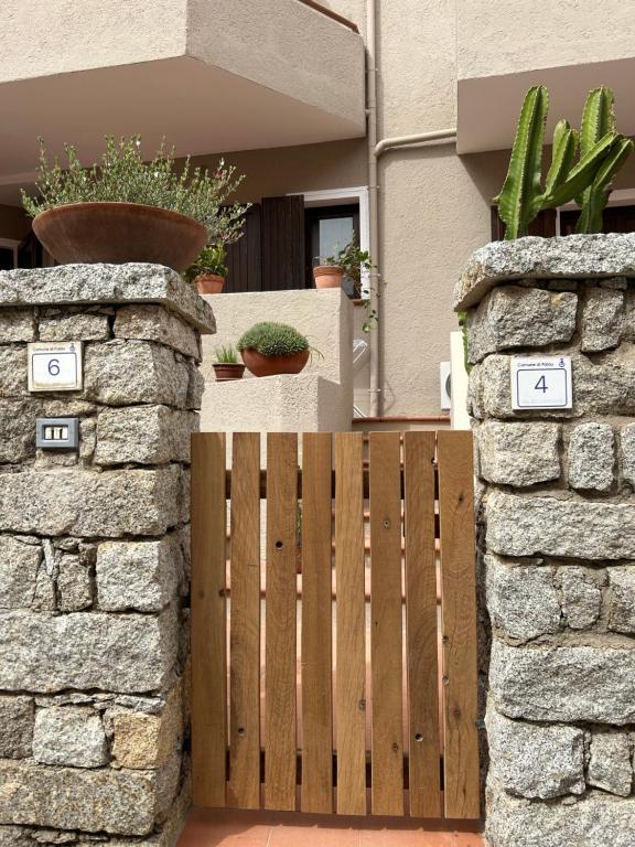 a wooden gate in front of a house with potted plants at Mare Fuori in Palau