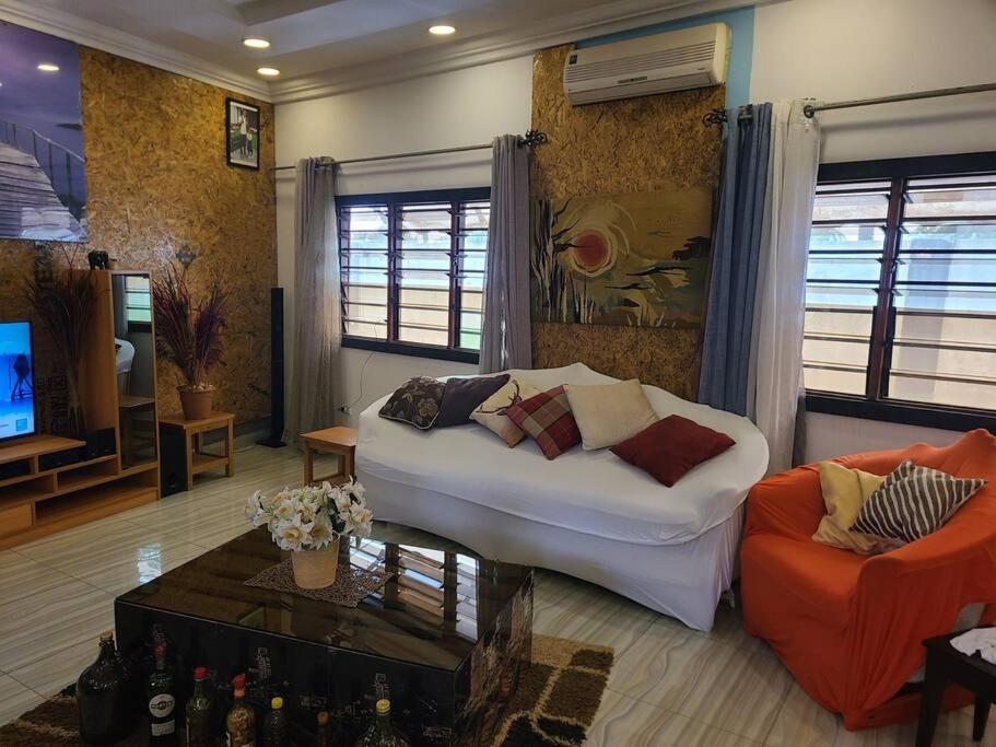 ein Wohnzimmer mit einem weißen Sofa und einem TV in der Unterkunft Résidence GreenArt Mamert et services in Porto-Novo