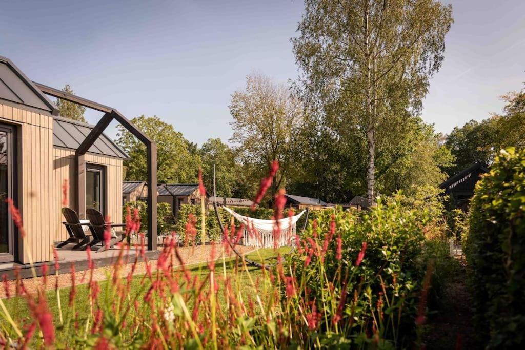 a garden with a hammock in the middle of a yard at Fred I Tiny House op de Veluwe in Epe