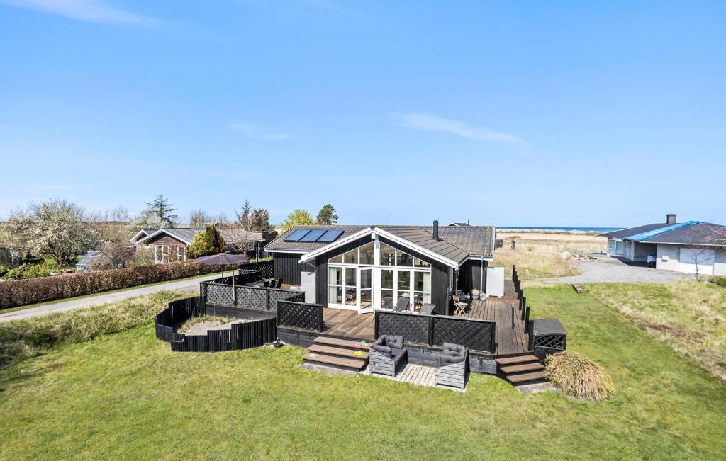 a house with a solarium on a grass field at Amazing Home In Frederikshavn in Frederikshavn