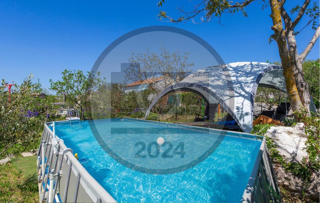 a swimming pool in a garden with an arbor around it at Pet Friendly Home In Labin With Wifi in Labin