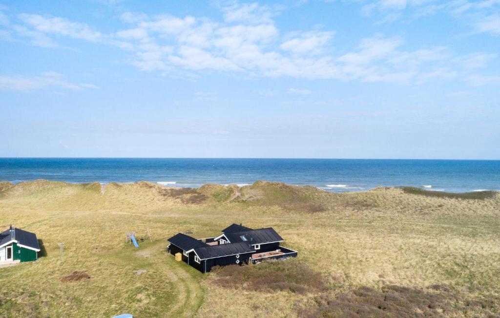 two houses on the beach near the ocean at Beach Front Home In Hjørring With Sauna in Hjørring