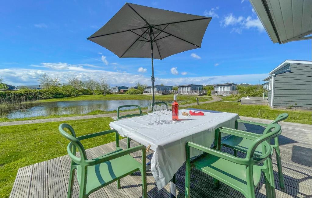 una mesa con sombrilla y 2 sillas en Pet Friendly Home In Lauwersoog With Kitchen, en Lauwersoog