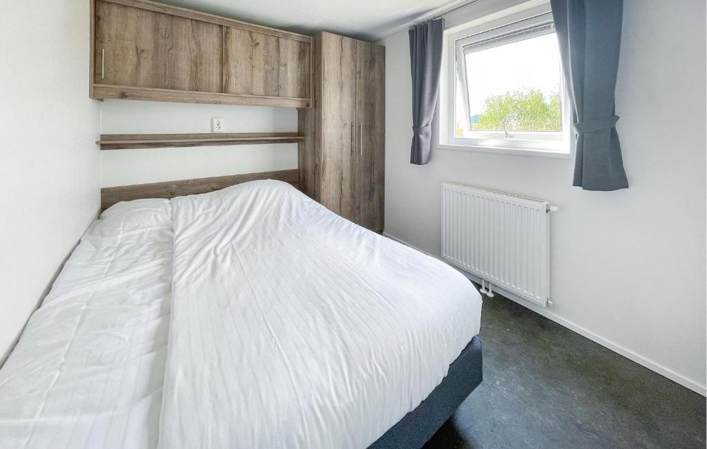 sypialnia z białym łóżkiem i oknem w obiekcie Pet Friendly Home In Lauwersoog w mieście Lauwersoog