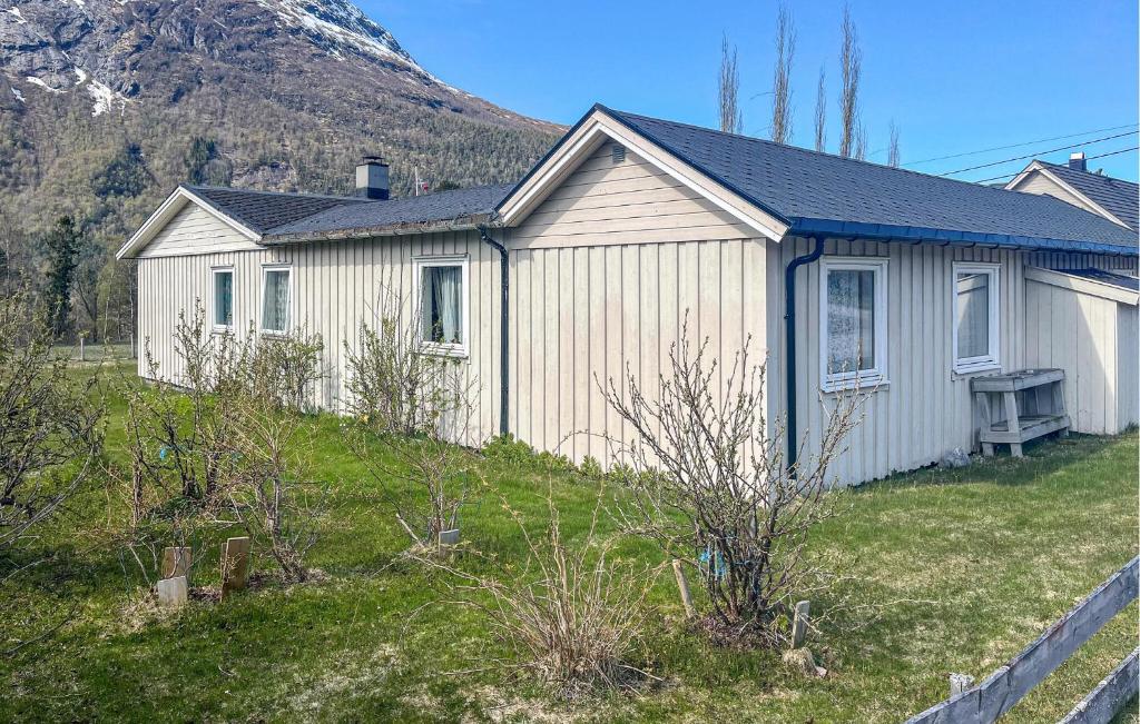 a white house with a mountain in the background at 2 Bedroom Gorgeous Apartment In Eresfjord in Nauste