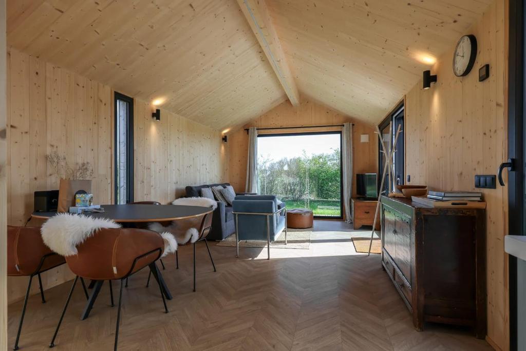 een kamer met een tafel en stoelen in een kamer bij Hello Zeeland - Tiny House Zeeuwse Liefde 2 in Westkapelle