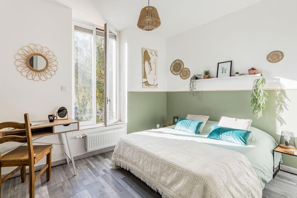 une chambre avec un lit, un bureau et une fenêtre dans l'établissement Le Zénith spacieux et central, à Saint-Étienne