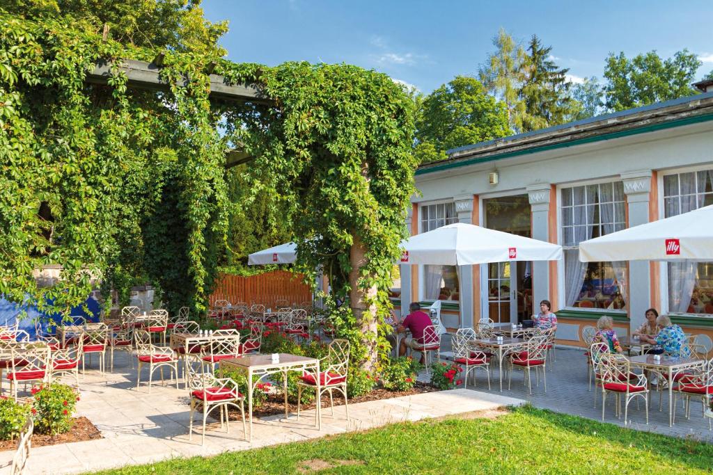 an outdoor patio with tables and chairs and umbrellas at Spa Resort PAWLIK-AQUAFORUM in Františkovy Lázně