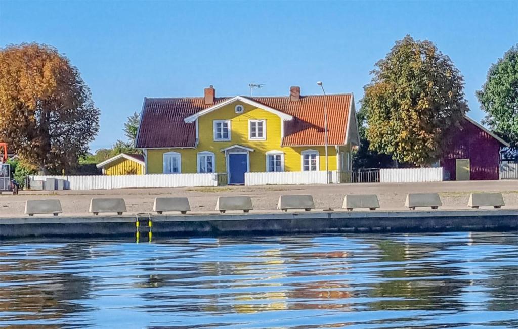 uma casa amarela ao lado de um corpo de água em Beautiful Home In Bergkvara With House Sea View em Bergkvara