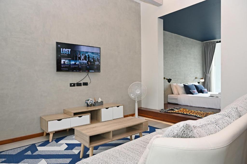 楠府的住宿－Villa Mahaphrom，客厅配有沙发和墙上的电视