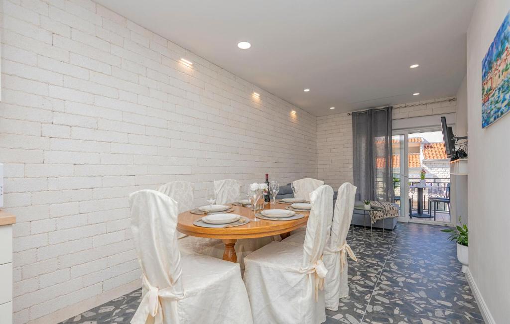 comedor con mesa de madera y sillas blancas en Cozy Apartment In Makarska With Kitchen en Makarska