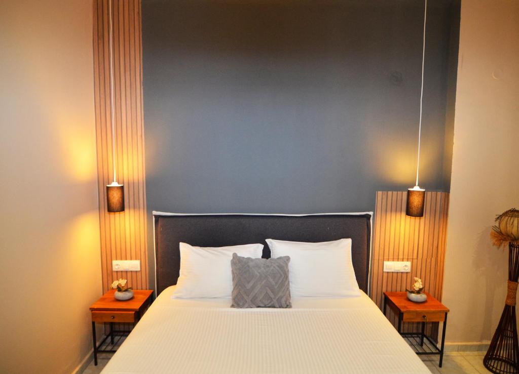 een slaapkamer met een groot wit bed en 2 nachtkastjes bij Relaxed Dream home in Chania