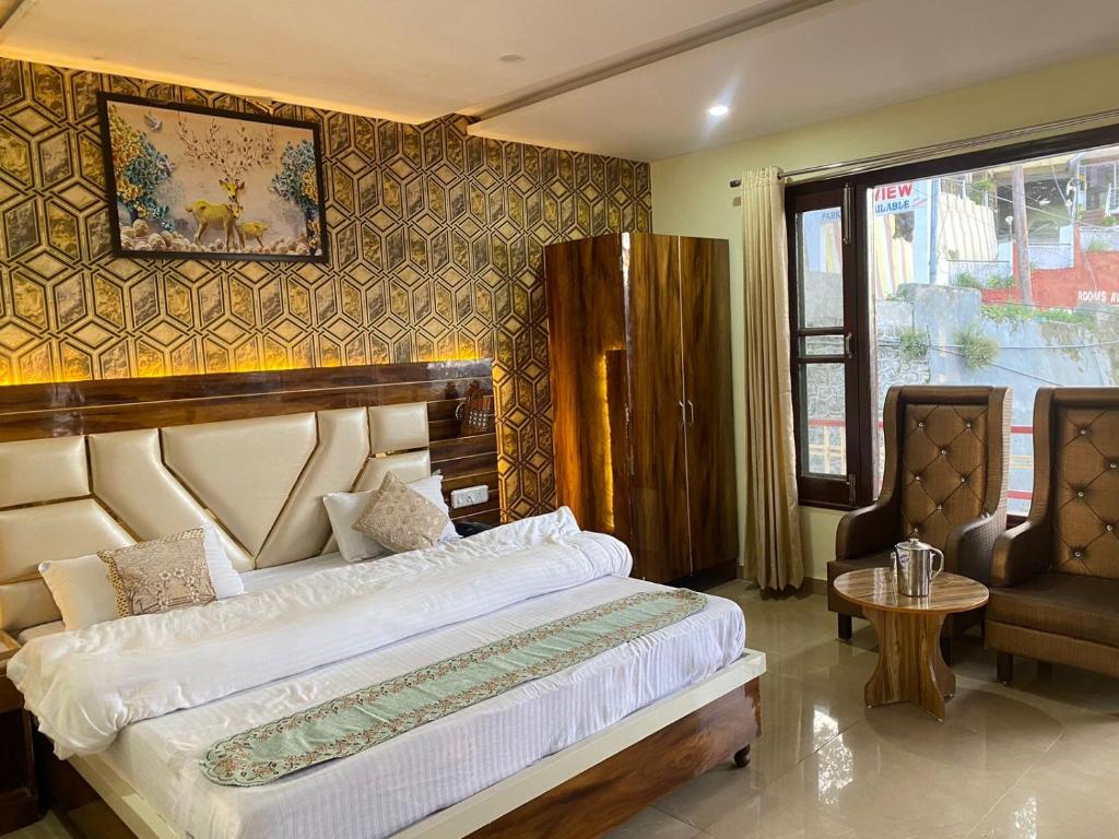 a bedroom with a large bed and a chair at MS RESORT in Dalhousie