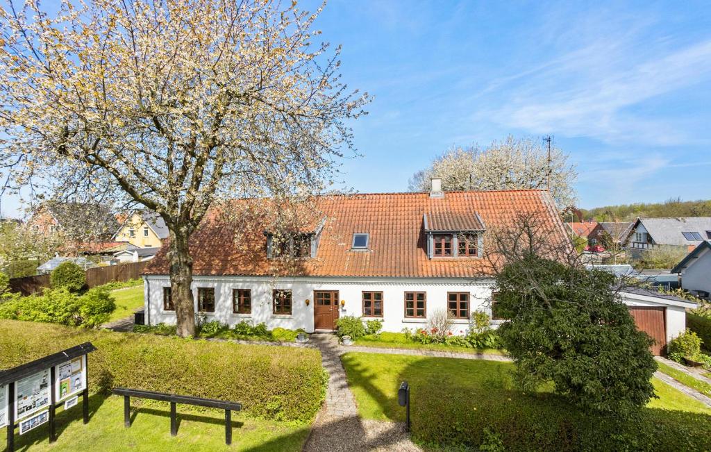 ein weißes Haus mit einem Baum und einer Bank in der Unterkunft 3 Bedroom Lovely Home In Svendborg in Svendborg