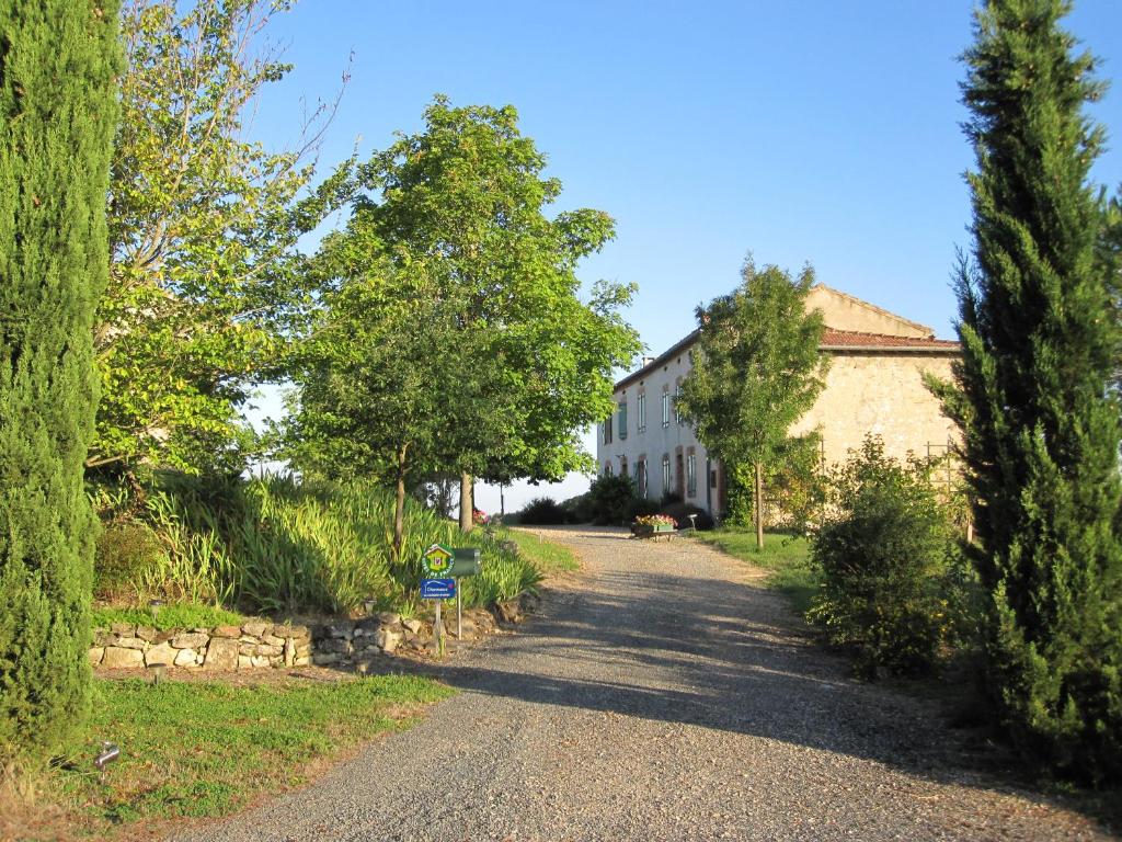 een weg met een gebouw en bomen aan de zijkant bij Bellegarde in Saint-Gauzens