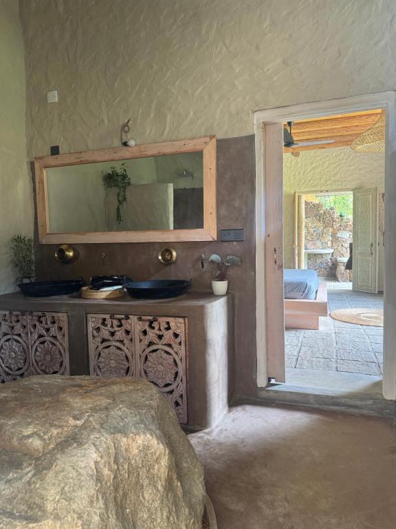 a bedroom with a dresser with a mirror and a door at Arawe Retreat in Ella