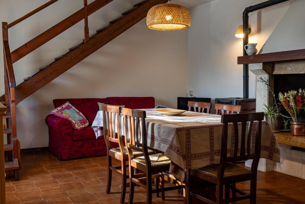 a dining room with a table and a red couch at Sunset House - Casa al Tramonto in Selva di Progno