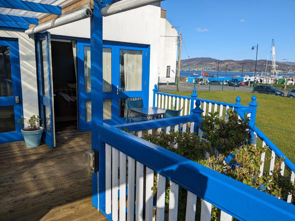 een blauw hek op een terras met uitzicht op een haven bij The Old Restaurant in Rathmullan