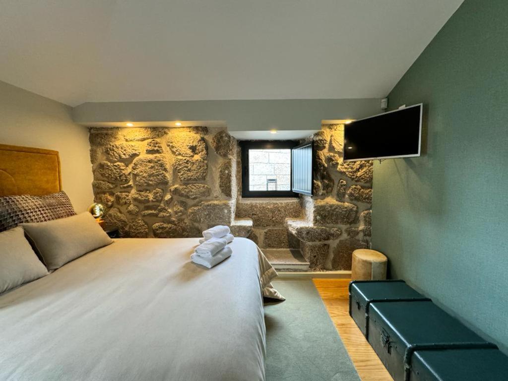 1 dormitorio con 1 cama grande y TV en GuestReady - An Amazing Retreat in Várzea do Douro, en Marco de Canaveses