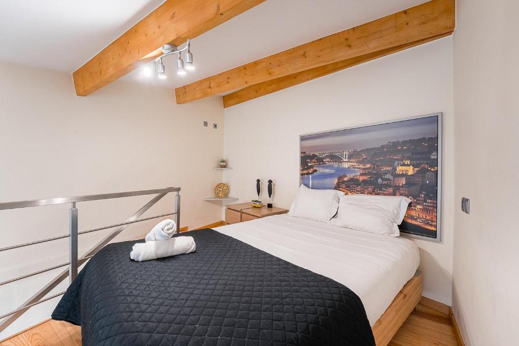 een slaapkamer met een groot bed in een kamer bij GuestReady - São Brás Mezzanine in Porto
