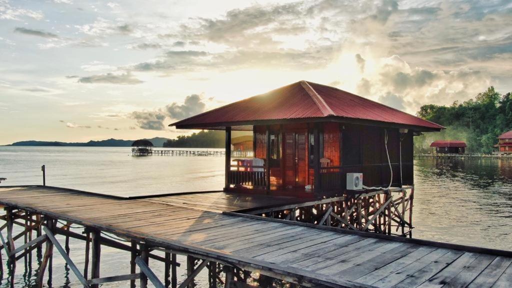 Coriana Dive Resort في Waisai: مبنى صغير على رصيف على هيئة ماء