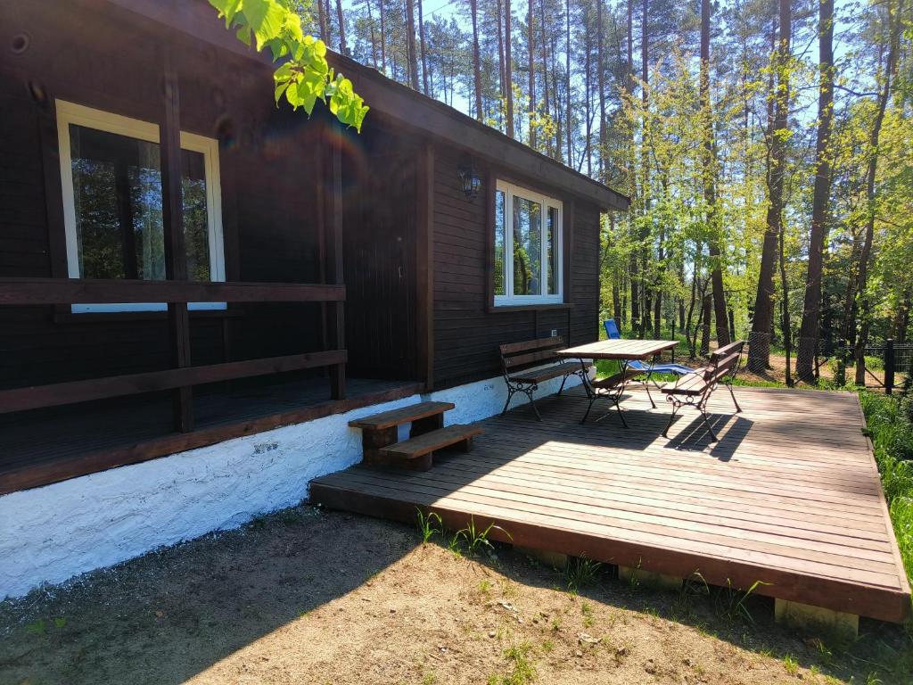 a cabin with a wooden deck and a picnic table at Pensjonat Sawica in Szczytno