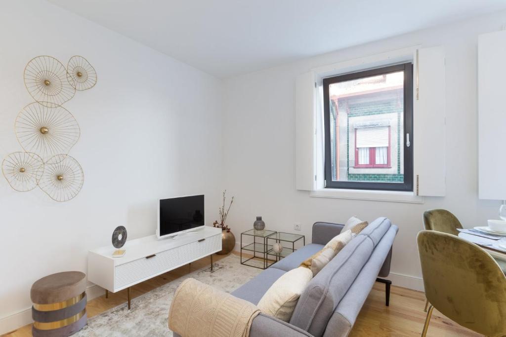 a living room with a couch and a tv at GuestReady - Cosy and Modern Apartment 4mins from Metro in Porto