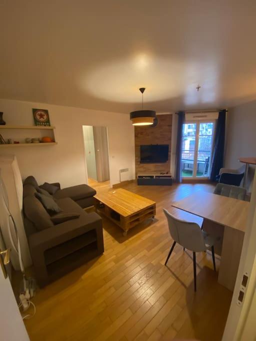 un salon avec un canapé et une table dans l'établissement Appartement avec terrasse - Paris Montrouge, à Montrouge