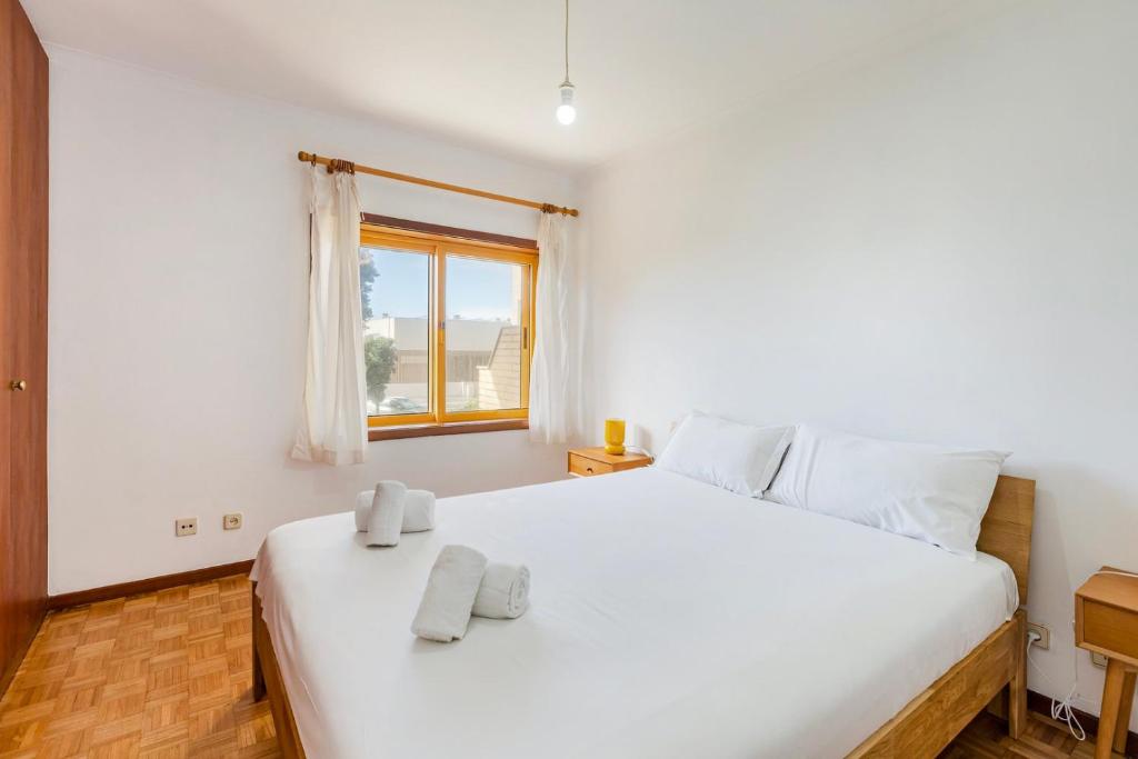 una camera da letto con un grande letto bianco con asciugamani di GuestReady - Exclusive Retreat in Lavra a Lavra