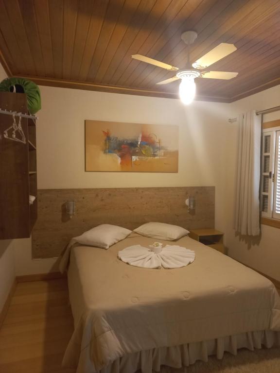 una camera con letto e ventilatore a soffitto di Pousada Eco Da Montanha a Passa Quatro