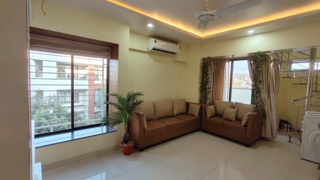 uma sala de estar com um sofá e uma janela em Blue Lagoon em Pune