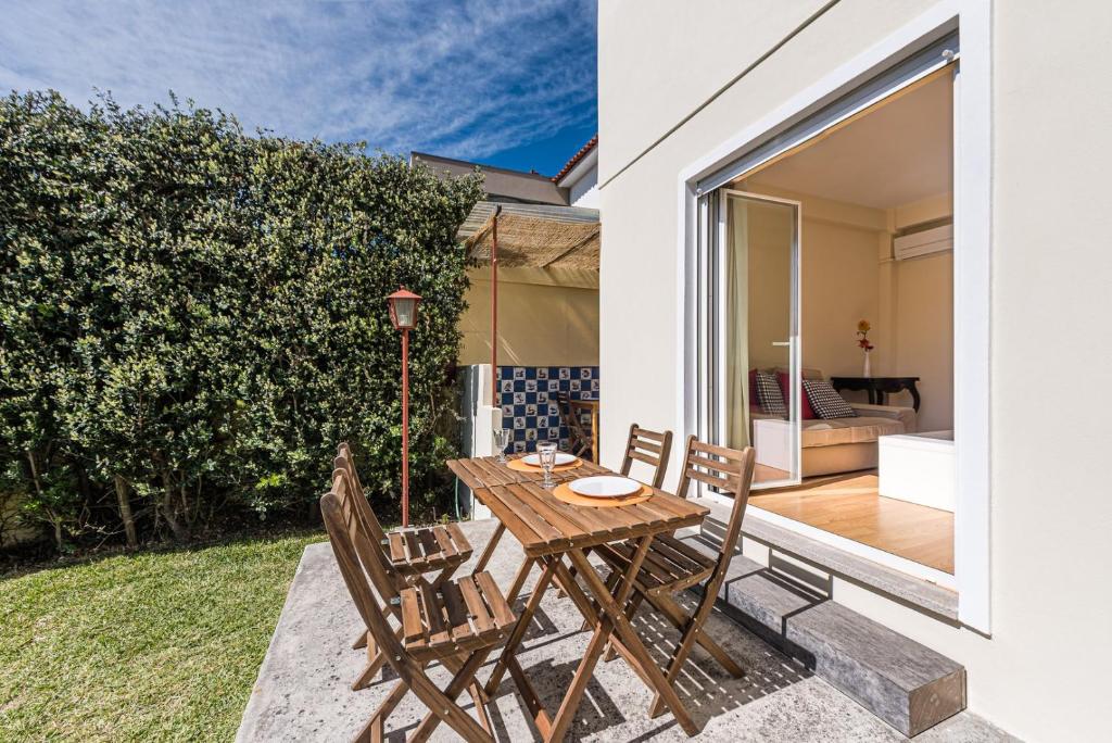 a patio with a wooden table and chairs at GuestReady - City & Beach Garden Home in Porto