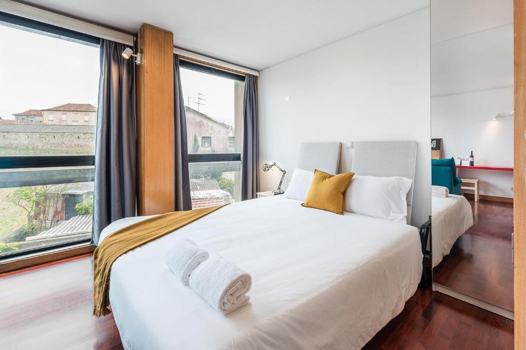 - une chambre avec 2 lits et une grande fenêtre dans l'établissement GuestReady - Zarco Studio, à Leça da Palmeira