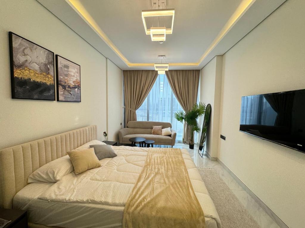 a hotel room with a bed and a television at Furnished studio استديو مفروش studio city in Dubai