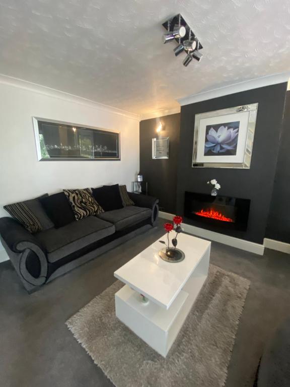 sala de estar con sofá y chimenea en The Brook House - Spacious 3 Bed Home From Home en Burton upon Trent