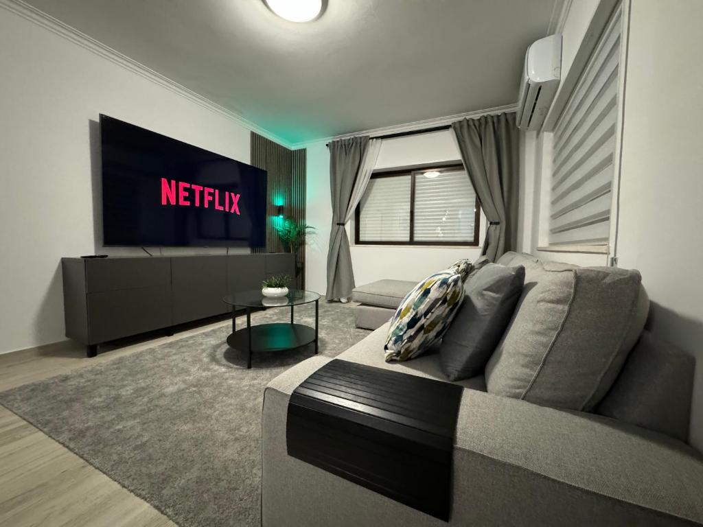 a living room with a couch and a television at Princess Retreat Beautiful Modern Aprt 2 min walk from Quarteira Beach in Quarteira