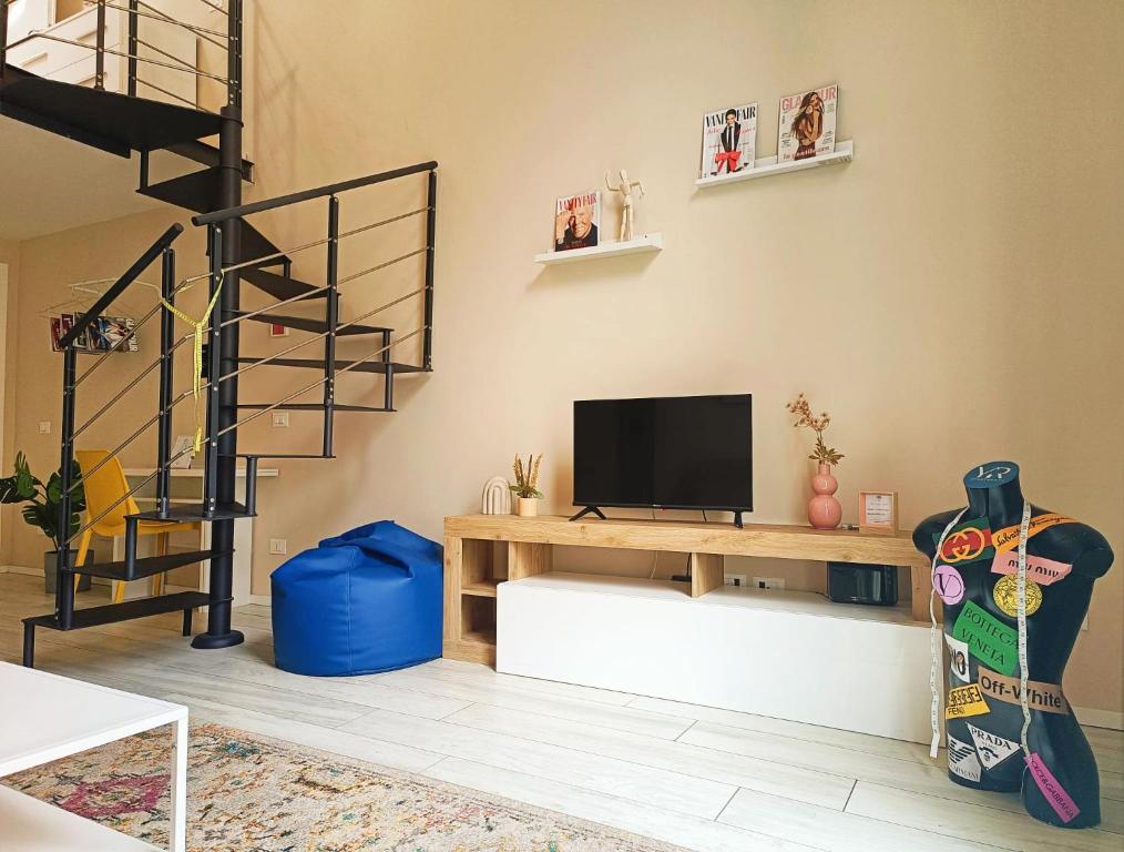 米蘭的住宿－YR Apartments Milan - Bocconi - Fashion Apartment，一间带电视和楼梯的客厅